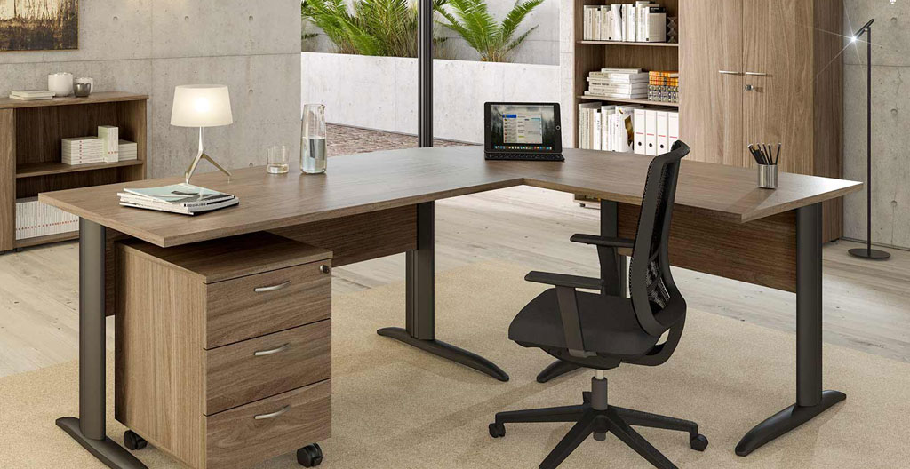 Bureau d'angle en bois avec retour sur caisson, chaise ergonomique en cuir, dans un espace lumineux avec grande baie vitrée