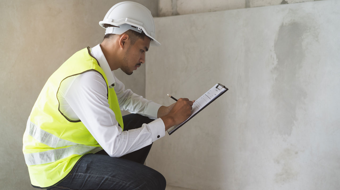 Expert en diagnostic immobilier inspectant les murs d'une maison ancienne pour détecter la présence de plomb ou d'amiante