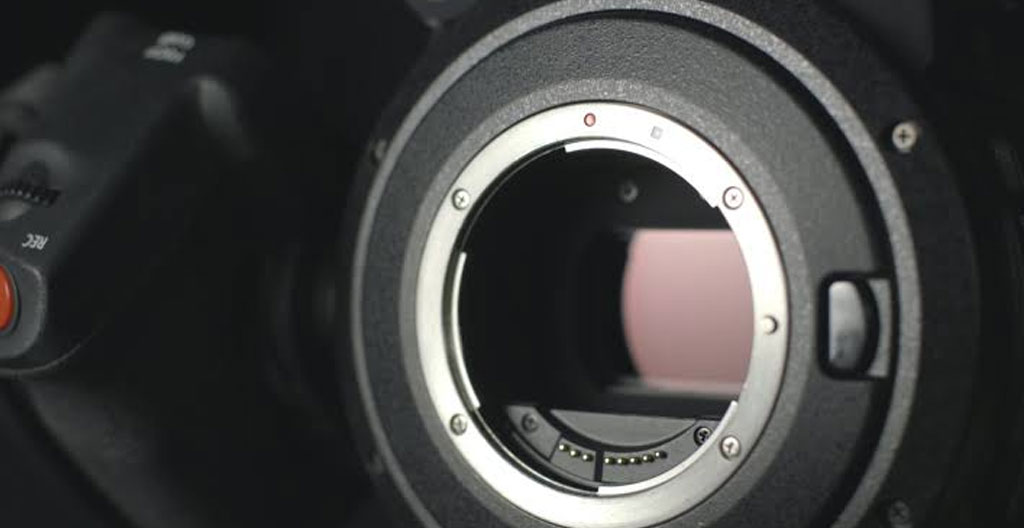 Différents formats de capteurs photographiques disposés sur table technique avec documentation en français dans environnement professionnel